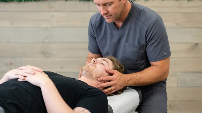 A practitioner performs a manual adjustment on a client